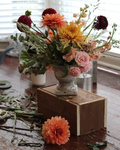 a wooden table topped with a vase filled with flowers